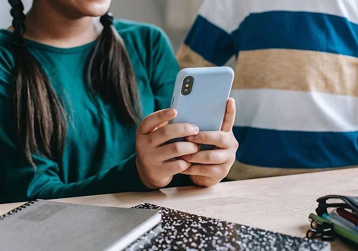Una alumna de Secundaria usando el móvil en el aula