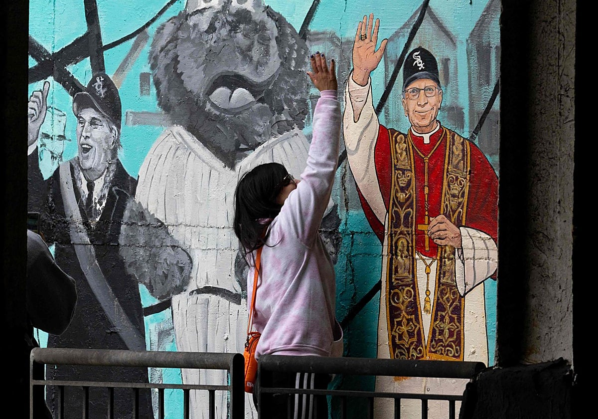 Una mujer choca con el grafiti del Papa León XIV durante el Jubileo de los deportistas