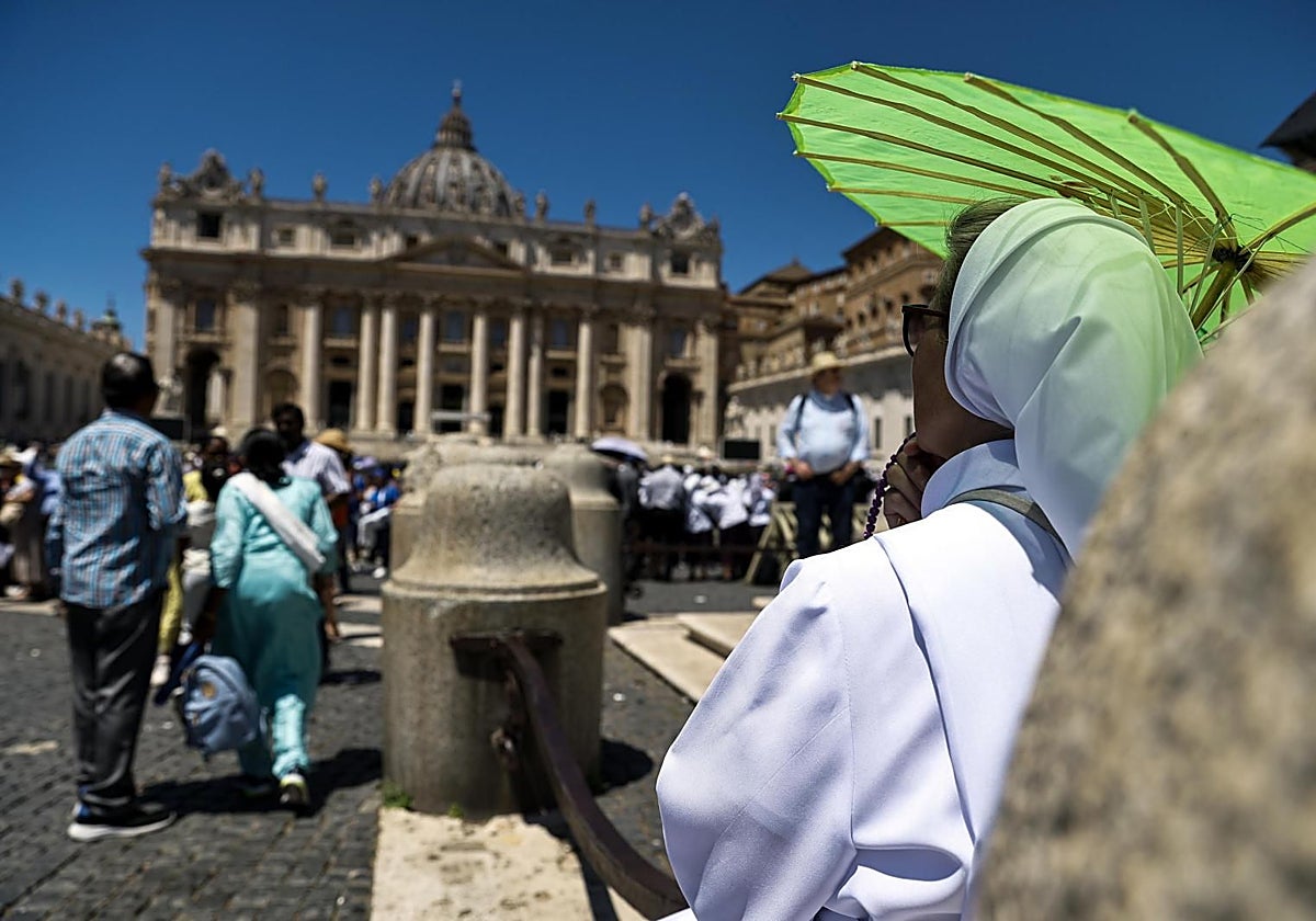 Una mujer se protege del sol con un paraguas  en la Plaza de San Pedro, El Vaticano.