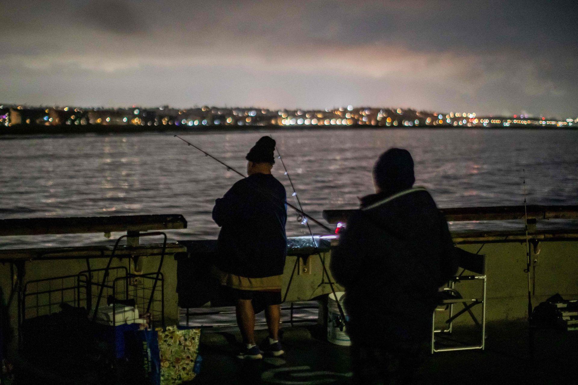 Hombres pescan en el muelle de Venice en medio de una alerta de tsunami en Los Ángeles, California, el 30 de julio de 2025.