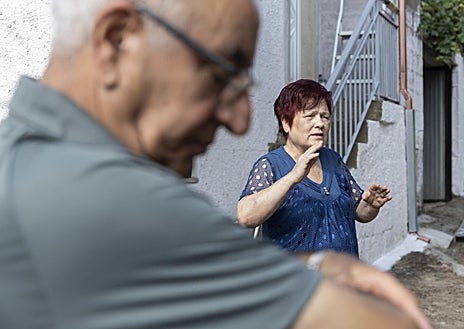 Imagen secundaria 1 - Virginia, rodeada de garrafas en A Veiga das Meás (arriba) / Josefina y Simeón, frente a su casa en Vilar de Cervos (izq.) / Helicóptero sobrevuela un pinar quemado en Vilardevós