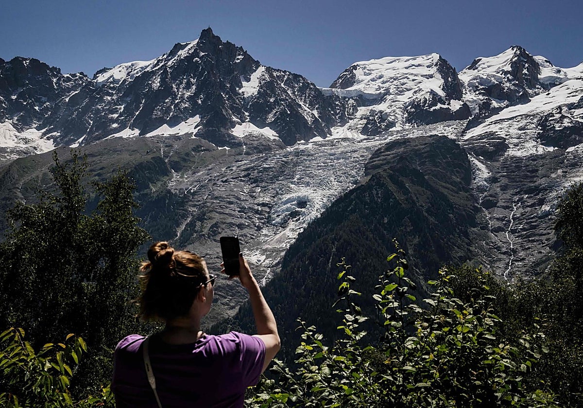 Una mujer utiliza su teléfono para hacer una fotografía en Chamonix-Mont-Blanc