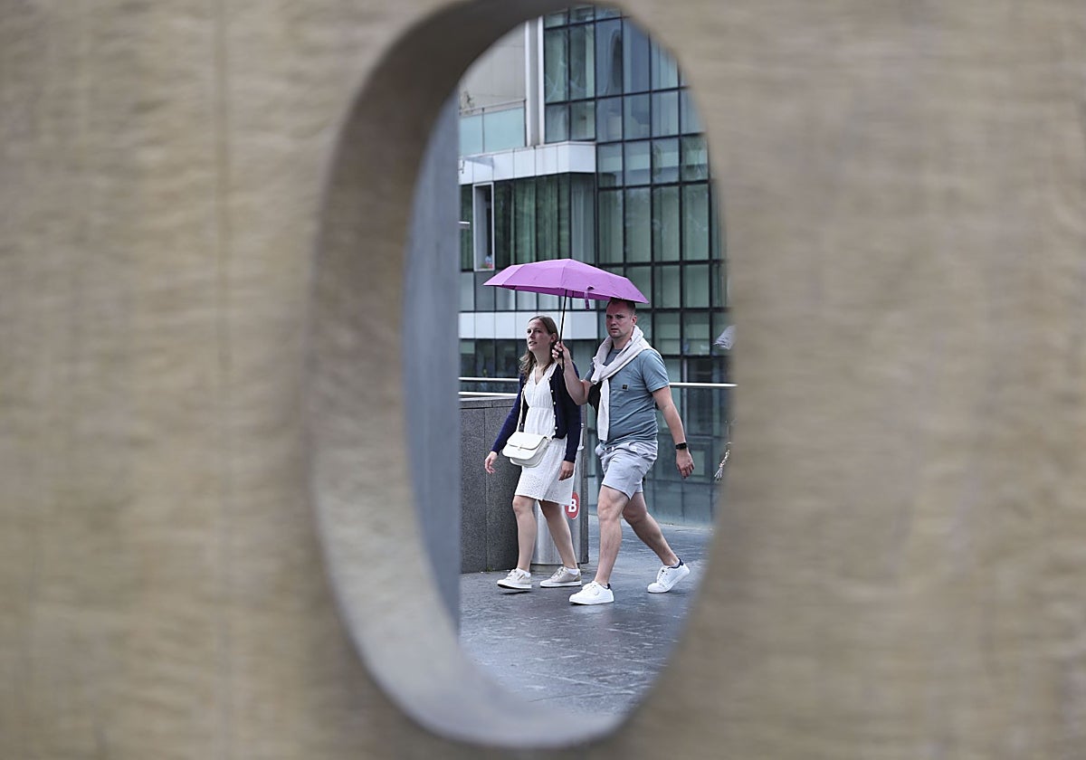 Una pareja se protege de la lluvia por el paso de la borrasca Erin