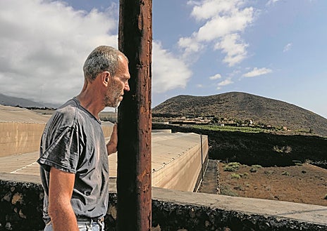 Imagen secundaria 1 - Arriba, Pino López Carmona, vecina de La Palma, posa en la puerta del contenedor habilitado como vivienda en el que reside desde 2021, cuando perdió su casa a causa del volcán. Abajo, izquierda, José Barreto, otro vecino que trabaja para poner a punto el terreno de su sobrino, afectado por el volcán en 2021. A su derecha, el presidente del Cabildo Insular de La Palma, Sergio Rodríguez