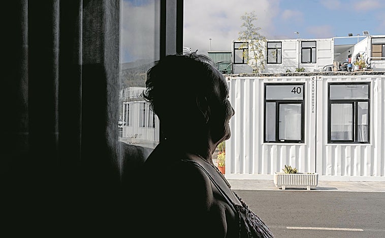 Imagen principal - Arriba, Pino López Carmona, vecina de La Palma, posa en la puerta del contenedor habilitado como vivienda en el que reside desde 2021, cuando perdió su casa a causa del volcán. Abajo, izquierda, José Barreto, otro vecino que trabaja para poner a punto el terreno de su sobrino, afectado por el volcán en 2021. A su derecha, el presidente del Cabildo Insular de La Palma, Sergio Rodríguez