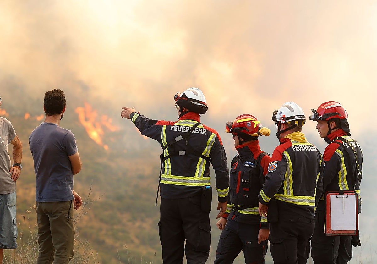 Varias personas observan el incendio forestal, a 24 de agosto de 2025, en La Baña, Encinedo, La Cabrera, León, Castilla y León