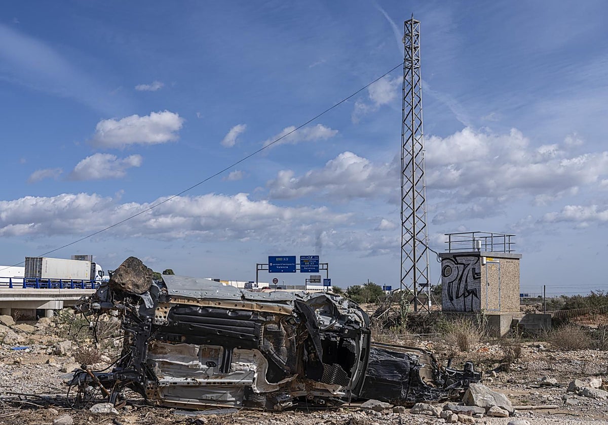 El caudalímetro del barranco del Poyo quedó destrozado por la crecida. Un año después siguen los coches destrozados a su lado y la valla que lo protegía enterrada en el suelo por la riada, lo que ha permitido que sea vandalizado con pintadas