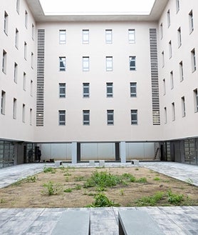 Imagen secundaria 2 - Arriba, el torno que da acceso a las habitaciones del centro abierto de la Zona Franca. Sobre estas líneas, una de las habitaciones, con dos literas, construidas por los propios presos, y la vista de uno de los patios interiores, al que dan los cuartos. Las ventanas no tienen rejas. 