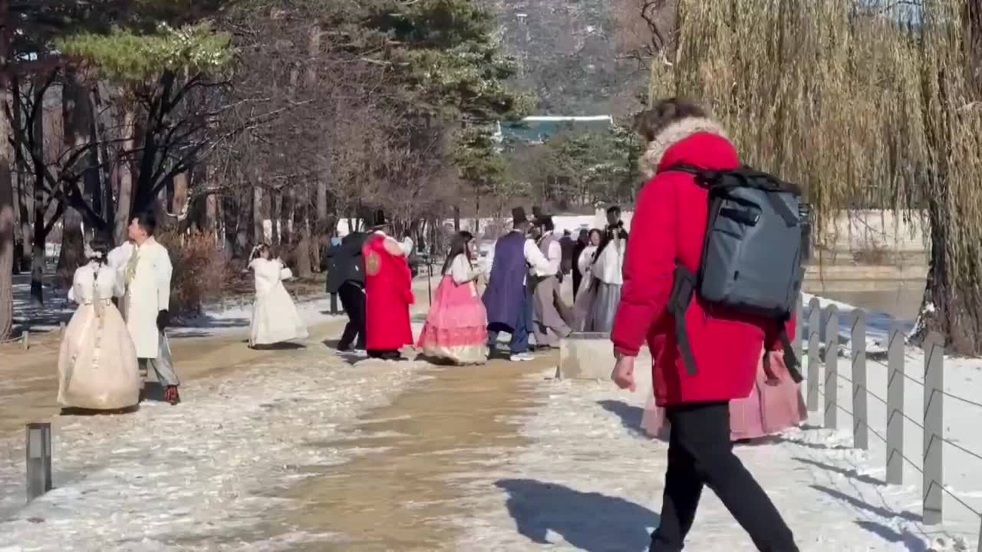 Turistas con trajes tradicionales coreanos visitan el palacio Gyeongbokgung de Seúl tras una nevada