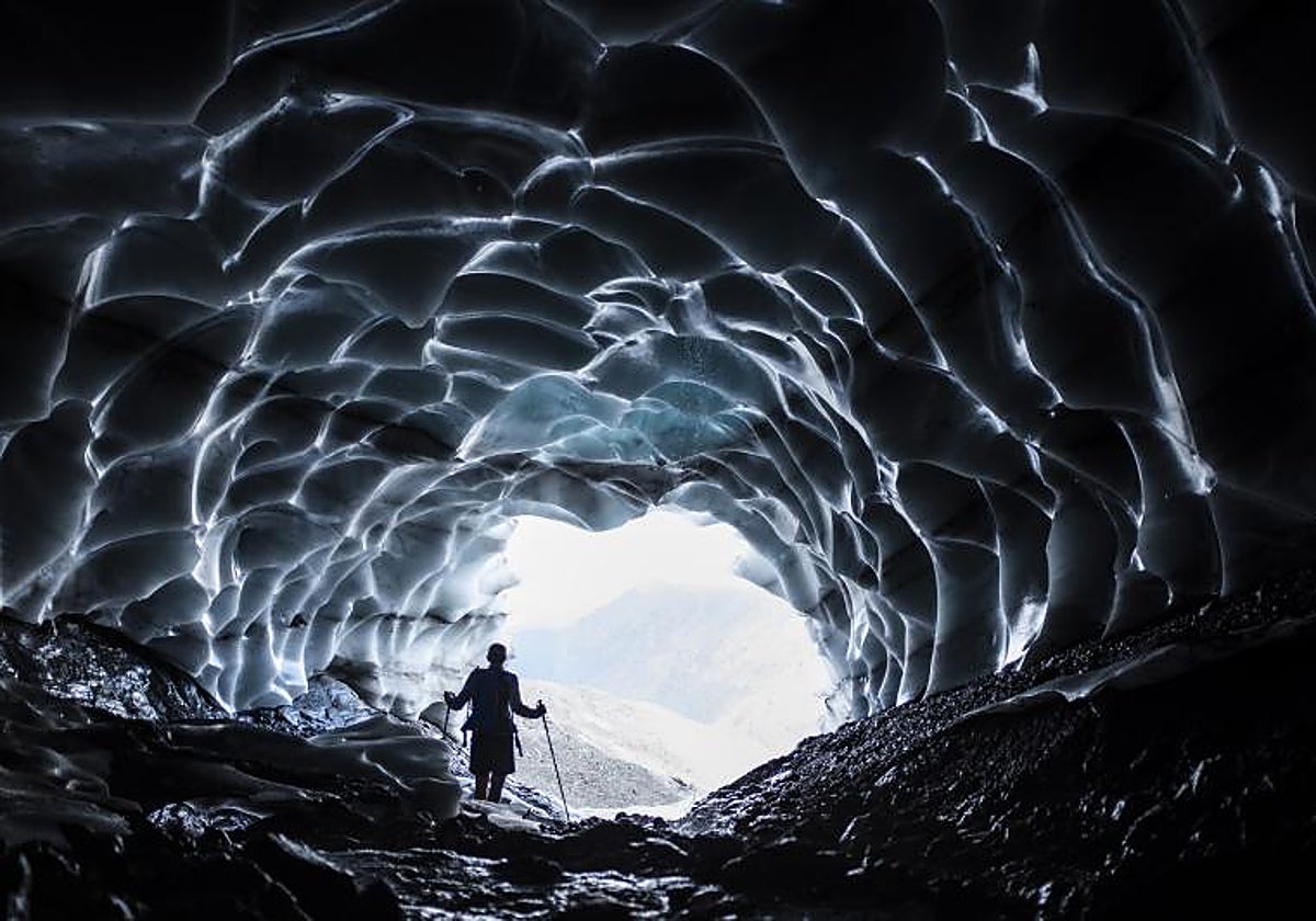 Un hombre camina por una cueva del glaciar Sardona descubierta por el deshielo