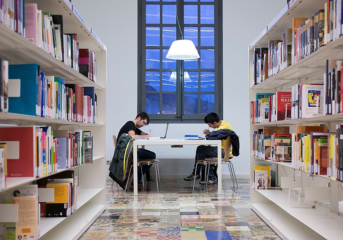 Dos estudiantes universitarios en una biblioteca pública de Barcelona