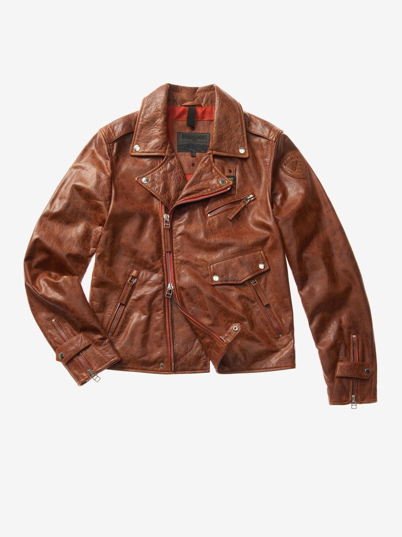 Cazadora Biker de piel resquebrajada Matthew de Blauer (694 €). De piel de oveja y forro de poliéster, de efecto vintage con tratamiento para un efecto resquebrajado. Cuello con doble solapa, cierre asimétrico en la parte delantera, desplazado hacia la derecha, con cremallera metálica doble cursor. Dos bolsillos frontales con cremallera, a la izquierda bolsillo en el pecho con cremallera oblicua y otro bolsillo más abajo con solapa y botones automáticos.