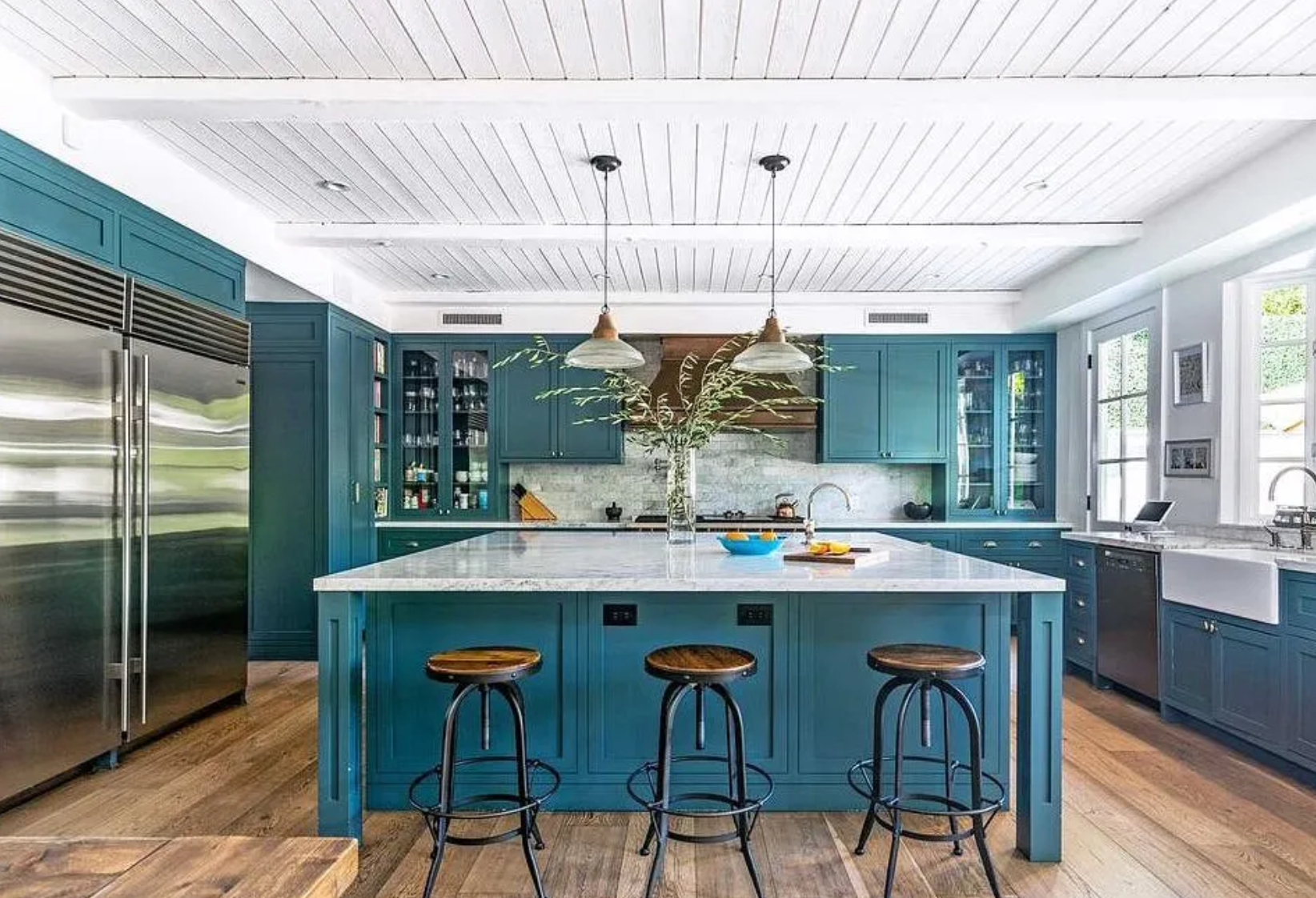 La cocina incluye llamativos gabinetes en azul aguamarina y encimeras de mármol
