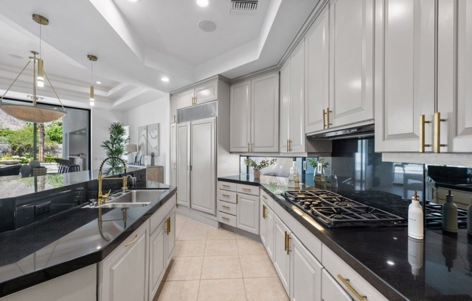 La cocina dispone de gabinetes de madera, electrodomésticos de acero inoxidable y una isla con barra de desayuno