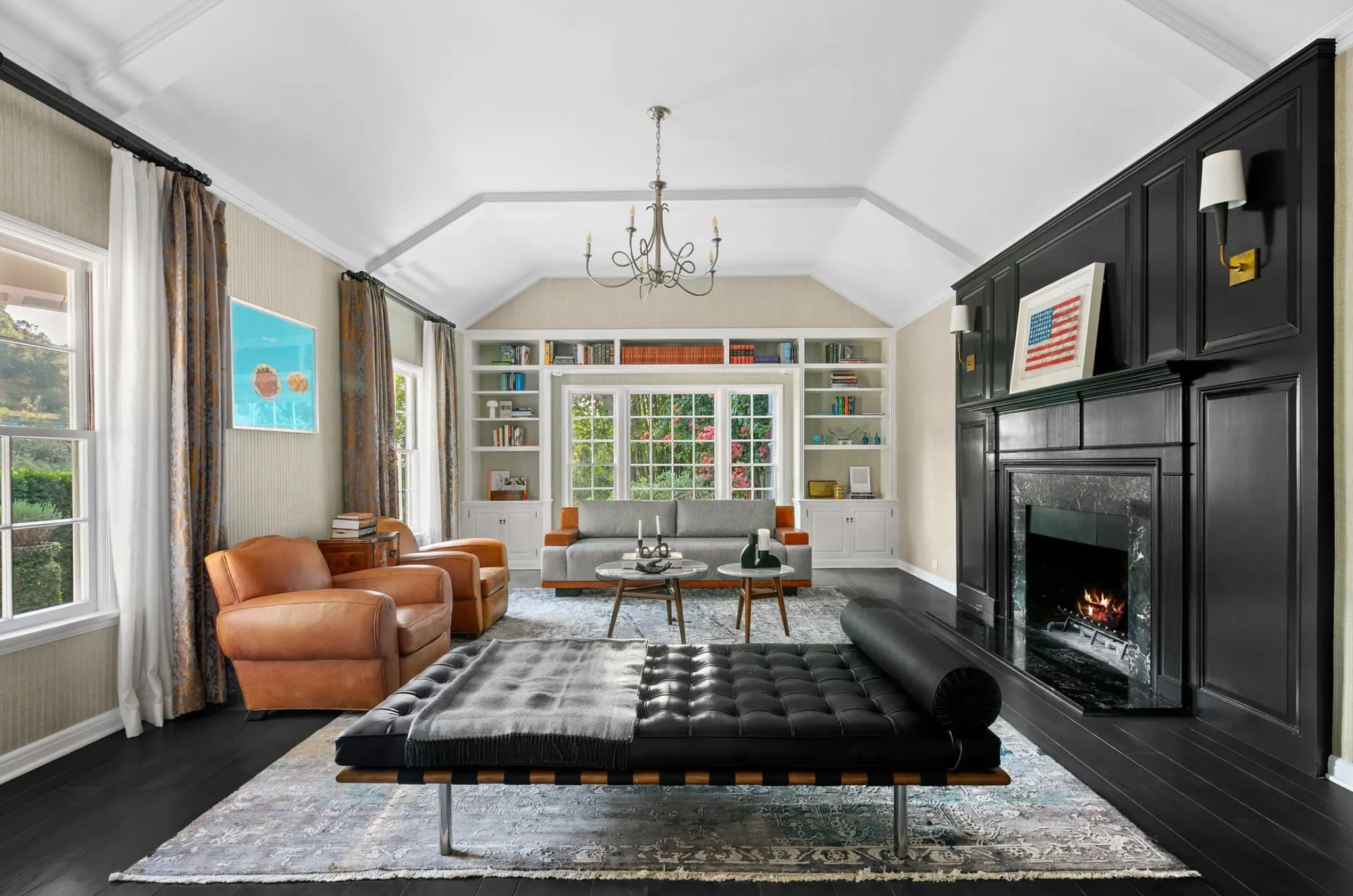 En su sala de estar destaca la elegante chimenea de mármol negro y la pared de madera en la que se encaja