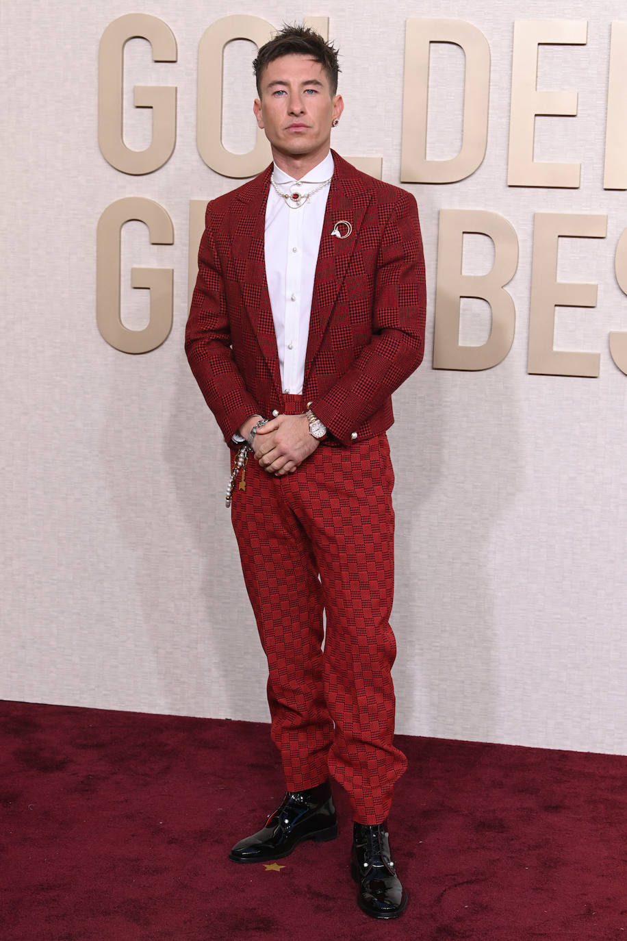 Barry Keoghan lució un look diferente formado por pantalón sastre rojo y camisa blanca de cuello redondo con botones perlados de la colección Primavera-Verano 2024 de Louis Vuitton. Lo completó con un cinturón de cadena dorado y un collar de perlas.