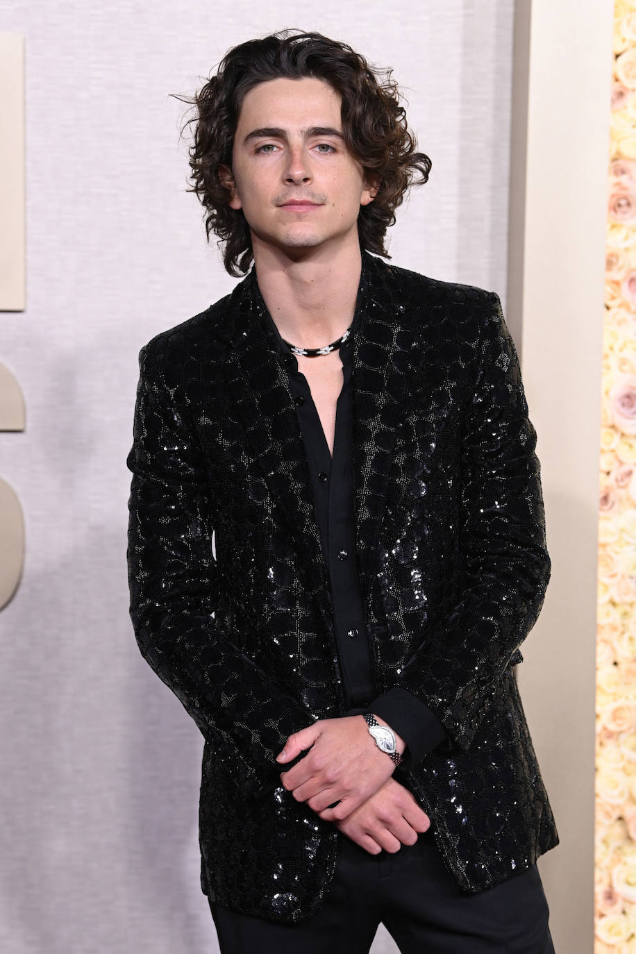 Timothée Chalamet lució uno de los relojes más originales, el modelo Crash de Cartier. De edición limitada, esta joya está confeccionada en oro rosa de 18 quilates engastado con 150 diamantes talla brillante. Además, el actor llevó una original gargantilla de la colección Cartier de oro blanco de 18 quilates, cerámica negra y diamantes.