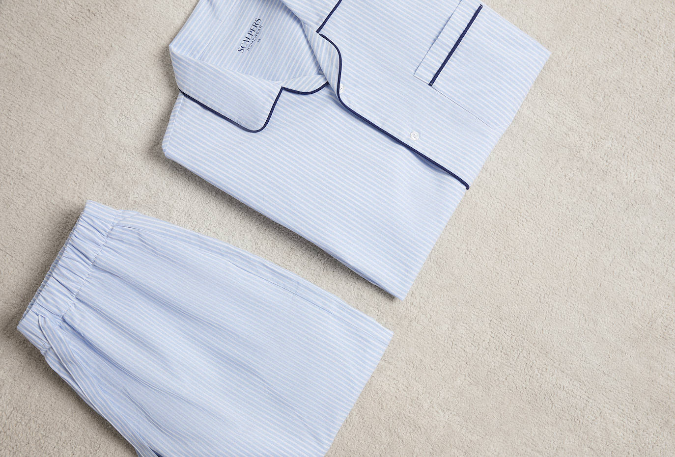 La nueva colección de pijamas de invierno de Scalpers es ideal para ese detalle romántico, toda una llamada al descanso y el bienestar en casa. Apostando por el equilibrio entre el estilo clásico y moderno,  las prendas están elaboradas con algodón 100% orgánico de origen portugués. Entre los modelos, Alfie es uno de los más clásicos, una reinterpretación de las rayas clásicas con un fit más actual, con cuello de solapa, cierre frontal con botones, manga larga, y ribeteado a contraste. El pijama se presenta en una funda de algodón personalizada. Precio: 79,90 euros