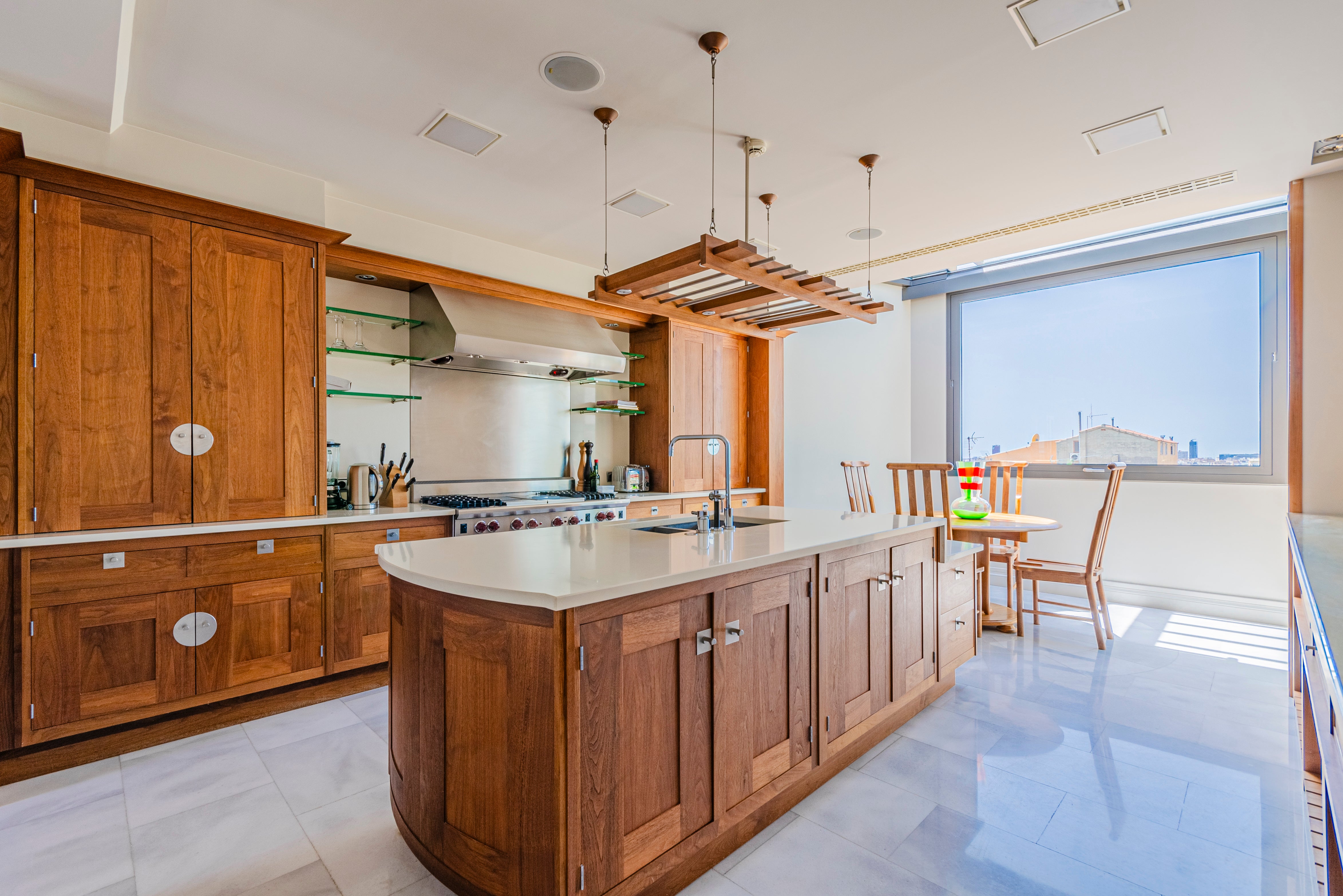 La cocina cuenta con gabinetes de madera, electrodomésticos de alta gama, una isla central con fregadero y espacio extra de almacenaje y un área de desayuno