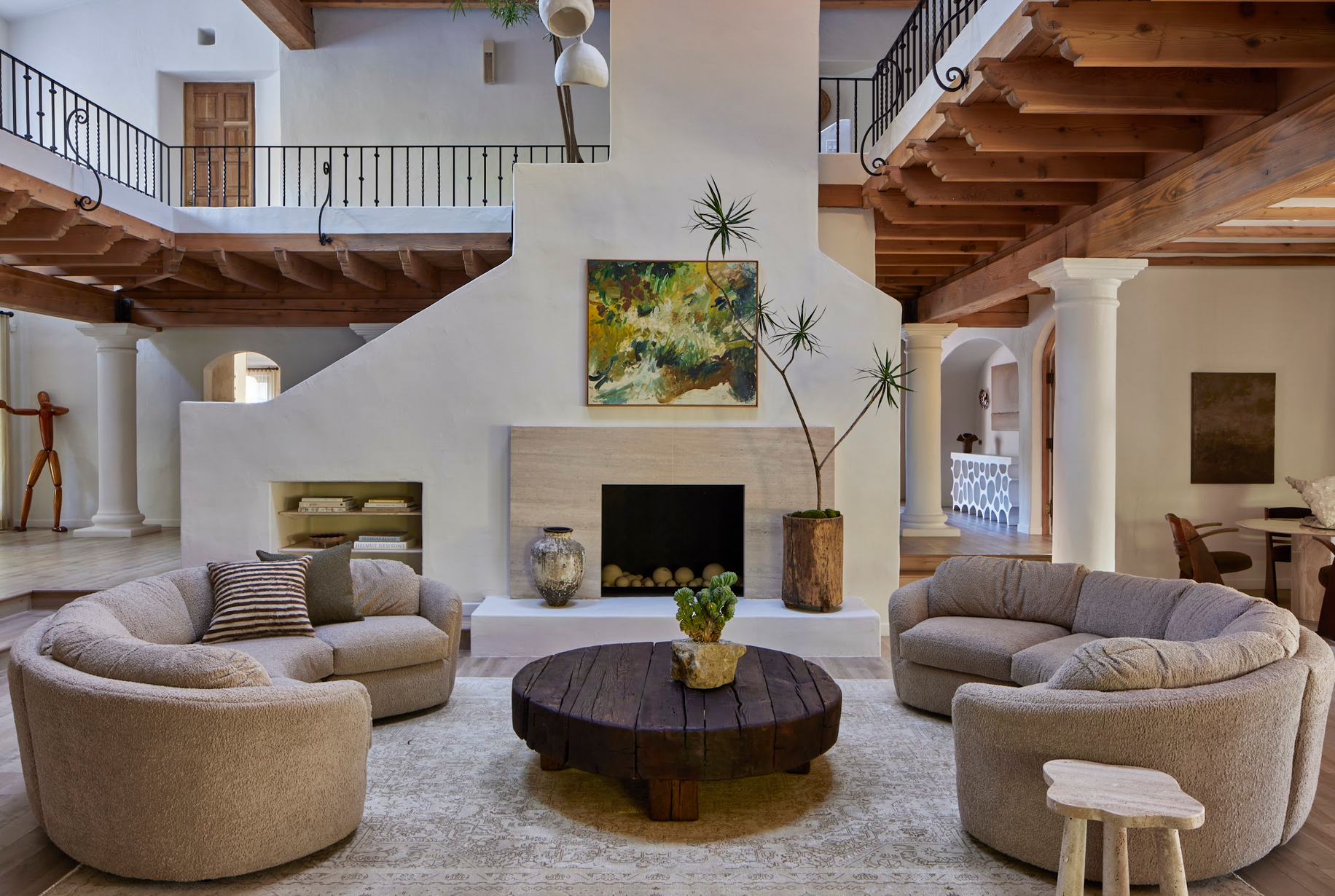 En su interior destaca una gran sala de estar a doble altura con chimenea de piedra y sofás 