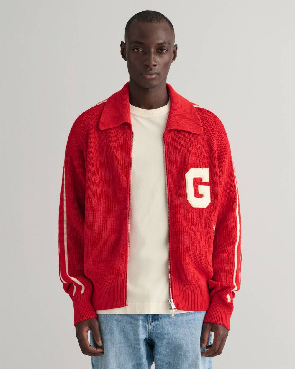 La esencia de las chaquetas deportivas en un modelo de punto rojo con cremallera de puños y solapa acanalados. Es de Gant. Precio: 280 euros.