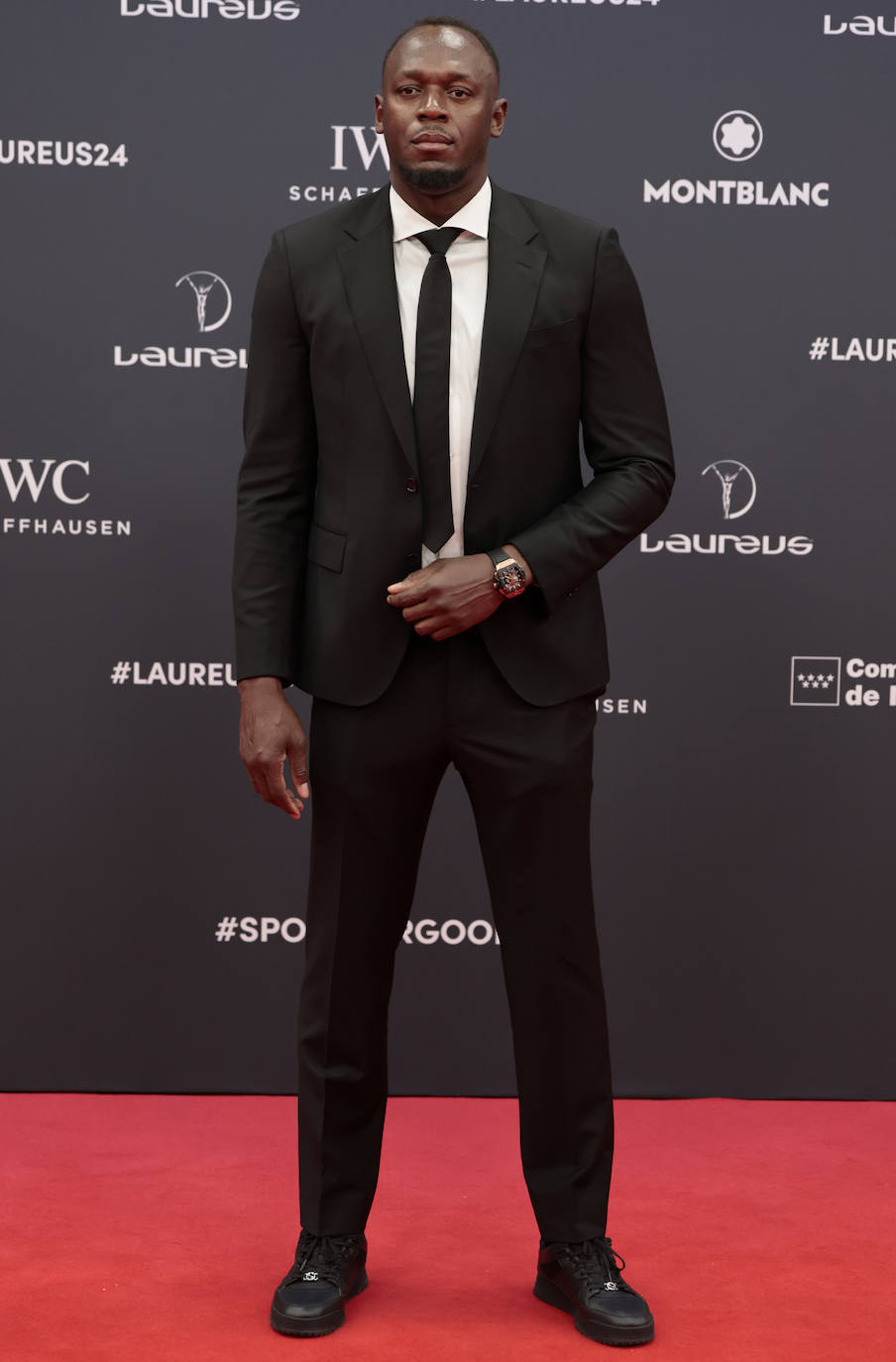 Usain Bolt, el mejor velocista de todos los tiempos, con traje negro. 