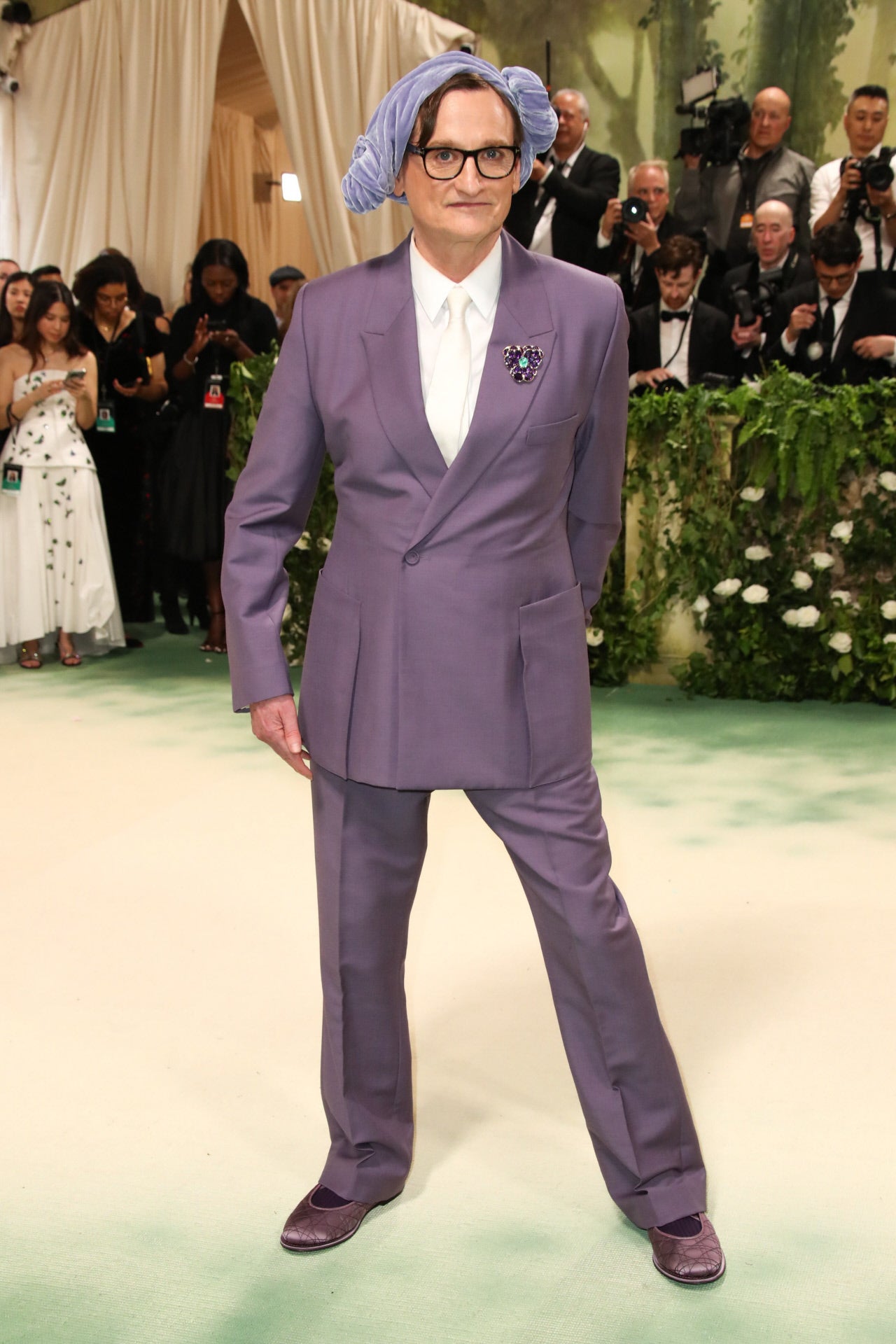 Hamish Bowles llevó un traje de lana morada de Dior, camisa blanca y bailarinas moradas, además de un tocado en el mismo tono. 
