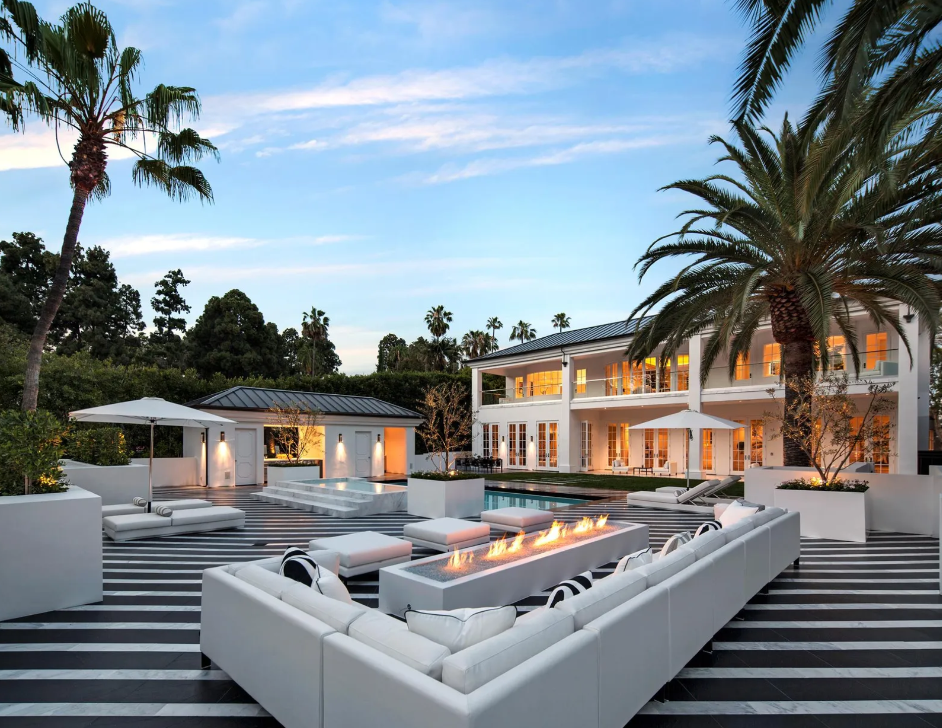 De la zona de solárium llama la atención el suelo con un llamativo patrón de rayas blancas y negras que se extiende, además, a la zona de estar con sofás y fogata 