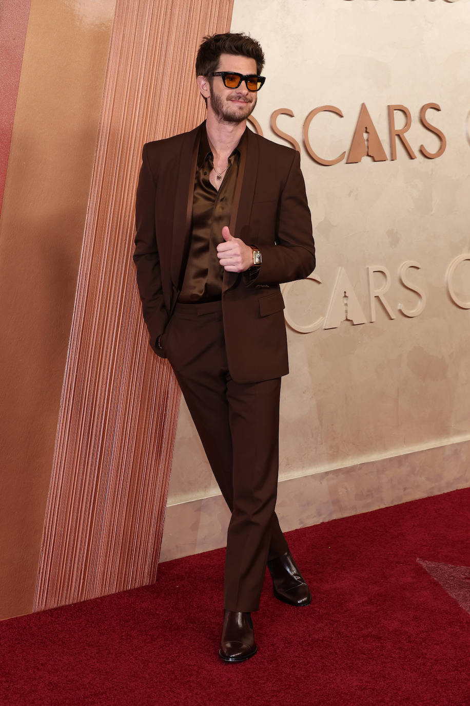 Andrew Garfield, fiel a su estilo, optó por un look monocolor en marrón, con camisa de seda abierta. Todo de Gucci. Lo combinó con sus gafas de sol, todo un clásico ya en la alfombra roja, y el reloj Reverso Tribute Duoface Calendar de Jaeger-LeCoultre.