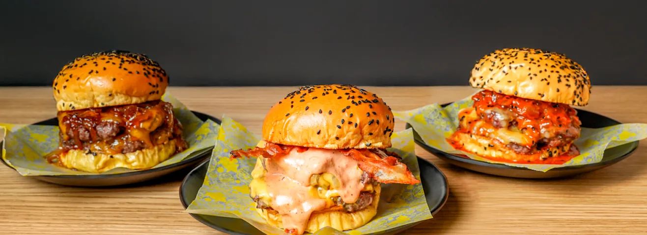 Este 19 de marzo, la celebración del Día del Padre se convierte en la excusa perfecta para compartir un momento especial a la mesa y sin salir de casa, eso sí siempre con un buen homenaje culinario. El último Gastrómetro de Just Eat reveló entre sus tendencias gastronómicas las smash burger como grandes protagonistas. Este próximo jueves sorprende al padre más 'foodie' con un homenaje en forma de hamburguesa como la Smash Cheese Bacon de Cesar’s Burgers ideal para amantes de los sabores clásicos y contundentes. Con su combinación de queso fundido, bacon crujiente y carne jugosa, es el homenaje perfecto para celebrar su día. Precio: desde 14,90 euros