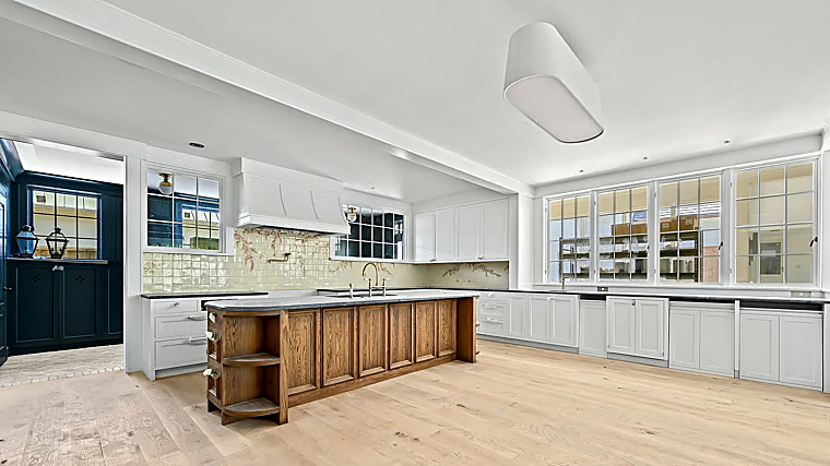 La cocina dispone de gabinetes blancos, electrodomésticos de alta gama e isla central