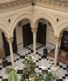 Imagen secundaria 2 - El Patio de los Naranjos, una de las 50 habitaciones del hotel y el patio central donde está la recepción y diversas estancias.