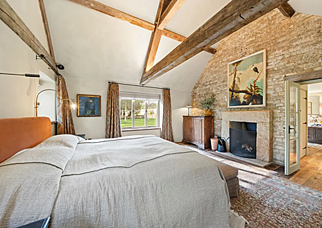 Imagen secundaria 1 - La vivienda presenta un estilo rústico con una cocina con gabinetes de madera y dormitorios con vigas vistas 