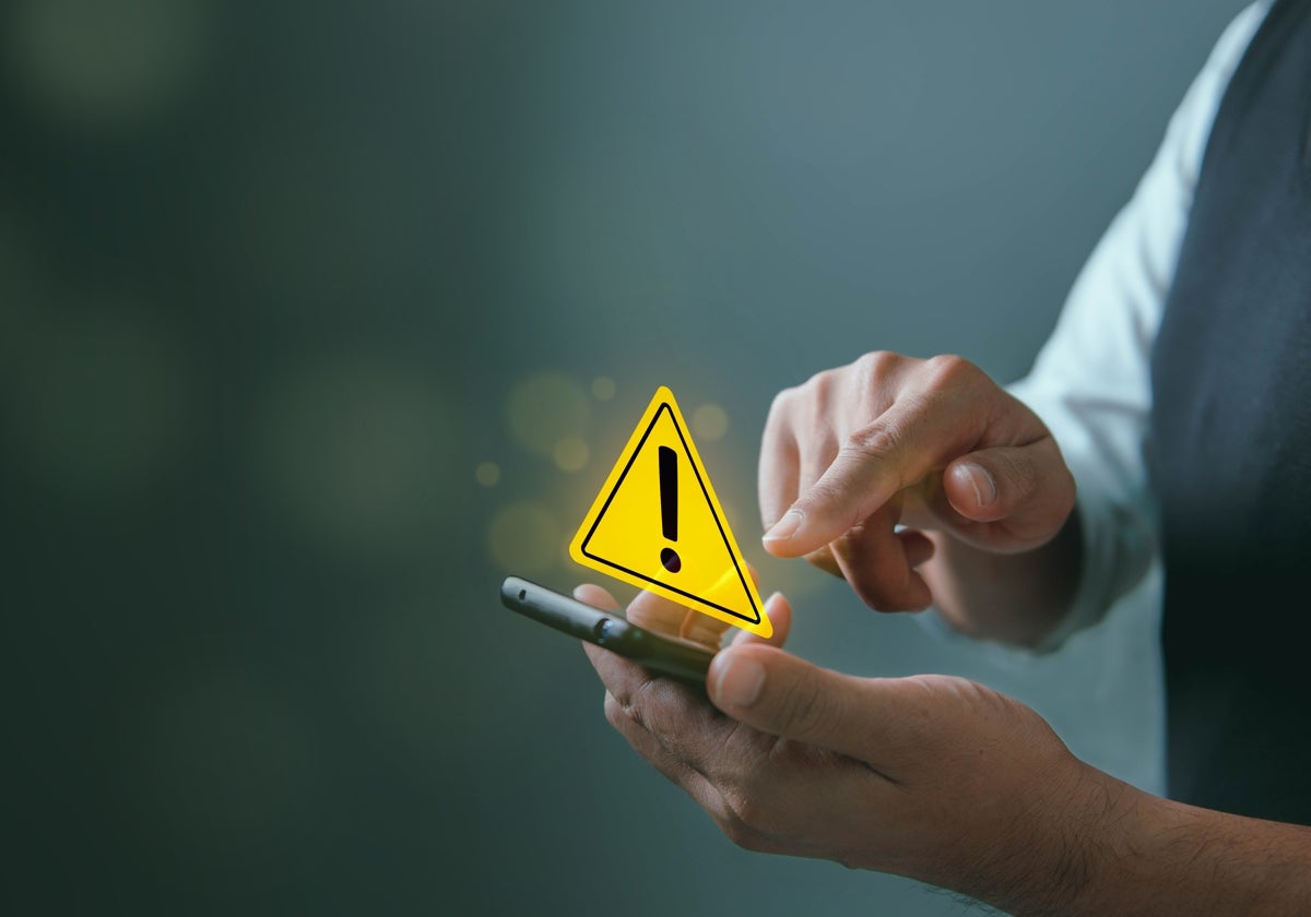 Fotografía de archivo de un hombre activando alertas para el móvil