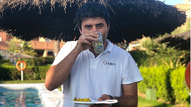 Guillermo Alonso sosteniendo un 'vasoplato', que cuenta con un orificio a uno de sus lados para depositar la bebida