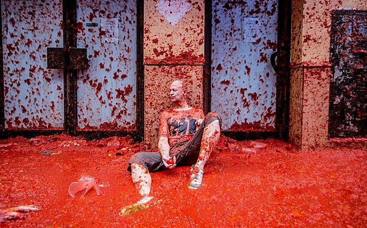 Imagen principal - Los participantes en la Tomatina, cada 31 de agosto, lanzan a la calle, unos contra otros, unos 130.000 kilos de tomates que vuelan y se estampan como un curioso y espectacular símbolo de alegría.