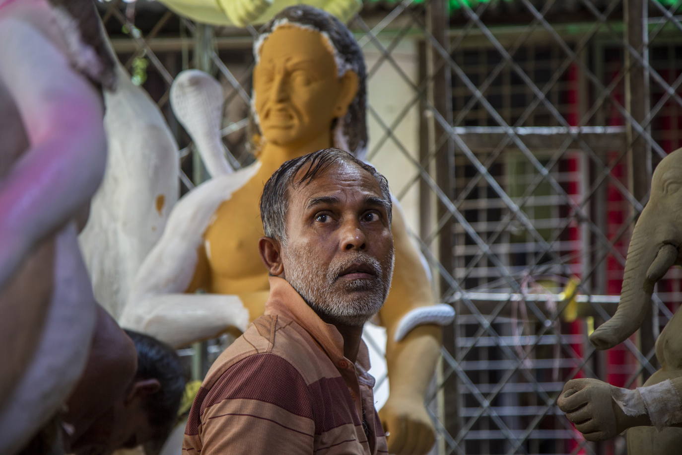 Un artista junto a una estatua que representa a Durga en Dhaka, Bangladesh