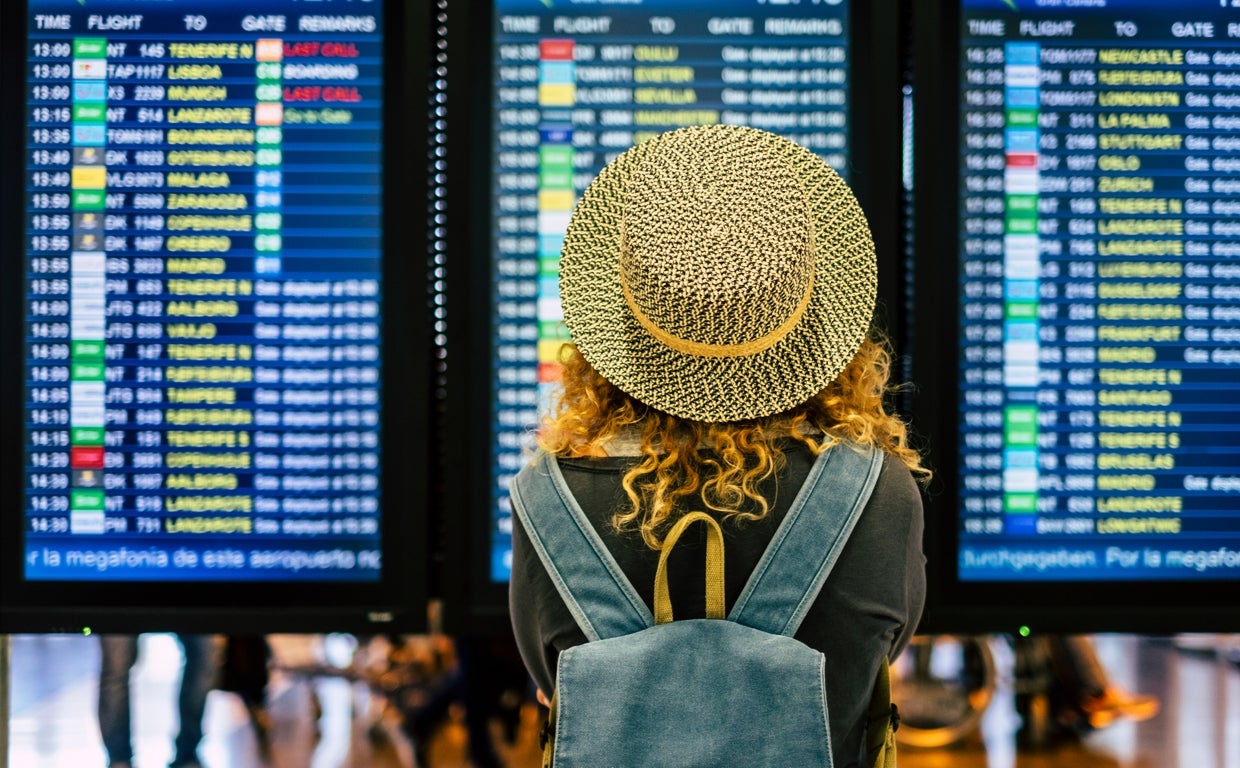 Una usuaria mira el panel de los vuelos de un aeropuerto