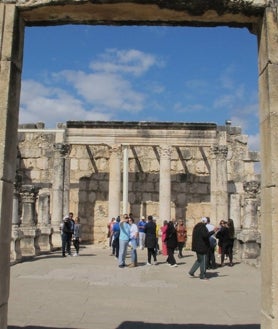 Imagen secundaria 2 - En la foto superior, un grupo de ortodoxos rumanos en el lado israelí del río Jordán. Al fondo, el lado jordano. Cientos de personas acuden cada día para revivir la ceremonia del bautismo. Sobre estas líneas, a la izquierda, el padre Ricardo Bustos, franciscano, en el monte Tabor. A la derecha, un rincón de la antigua sinagoga de Cafarnaúm. 