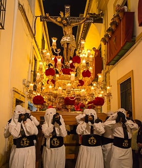 Imagen secundaria 2 - Los personajes que acompañan los pasos en Puente Genil (sobre estas líneas, a la izquierda) cubren sus caras con los 'rostrillos'. A la derecha, la Semana Santa de Écija. En la foto superior, Lucena.