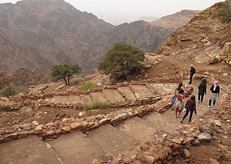 Imagen secundaria 1 - El camino desde la Pequeña Petra al Tesoro es uno de los tramos que forma parte de la sexta etapa del Jordan Trail, ruta de senderismo inaugurada en 2017 que va desde Um Qais, en el norte, hasta Aqaba, en el sur. En las fotos, el Wadi Araba y la subida a la meseta de Ad Deir. A la derecha, el Monasterio, una de las fachadas estrella de la antigua ciudad nabatea