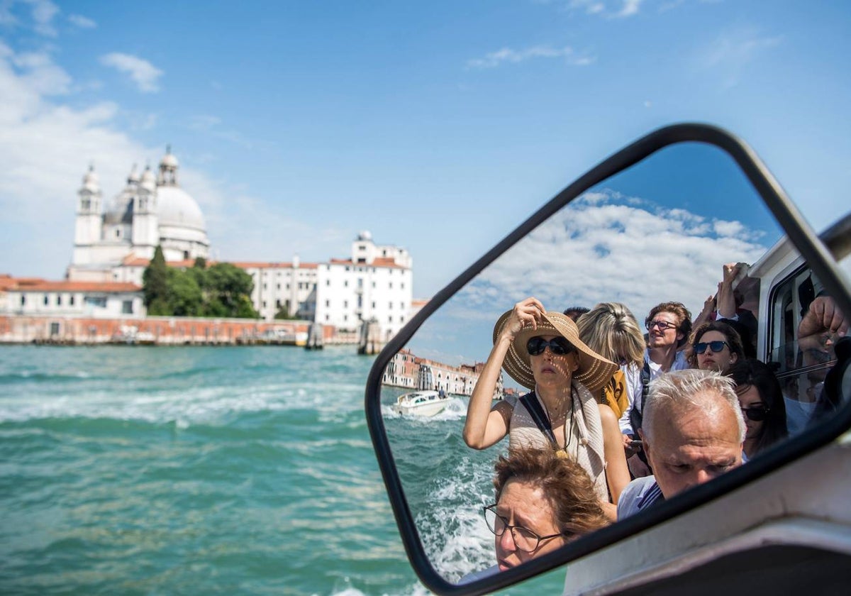 Turistas viajan en un vaporetto con destino a Venecia