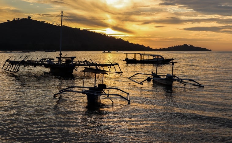 Imagen principal - En la foto superior, atardecer en la playa de Pemuteran, en el noroeste de Bali. Debajo, ceremonia en el templo Ulun Danu Bratan («cabeza del lago»). A la derecha, los campos de arroz de Jatiluwih