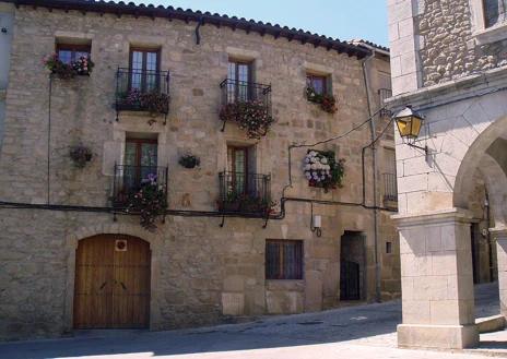 Imagen secundaria 1 - Vista del pueblo de Hoyos, una de sus calles y portada románica de la iglesia de Nuestra Señora del Buen Varón 