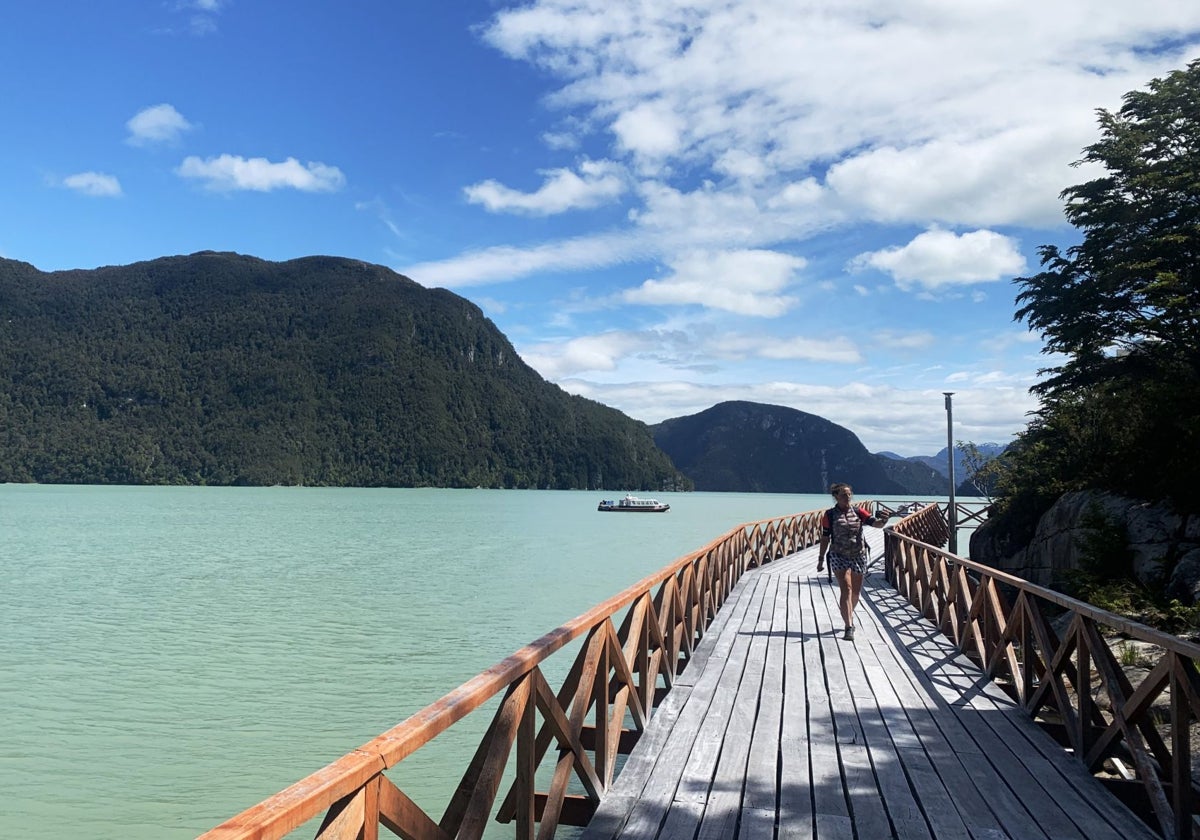 Una persona camina por una pasarela en Caleta Tortel, uno de los últimos pueblos de la Carretera Austral en el sur de Chile