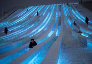 Los visitantes se deslizan en trineo sobre el hielo en una de las construcciones del Festival de Hielo y Nieve de Harbin, China