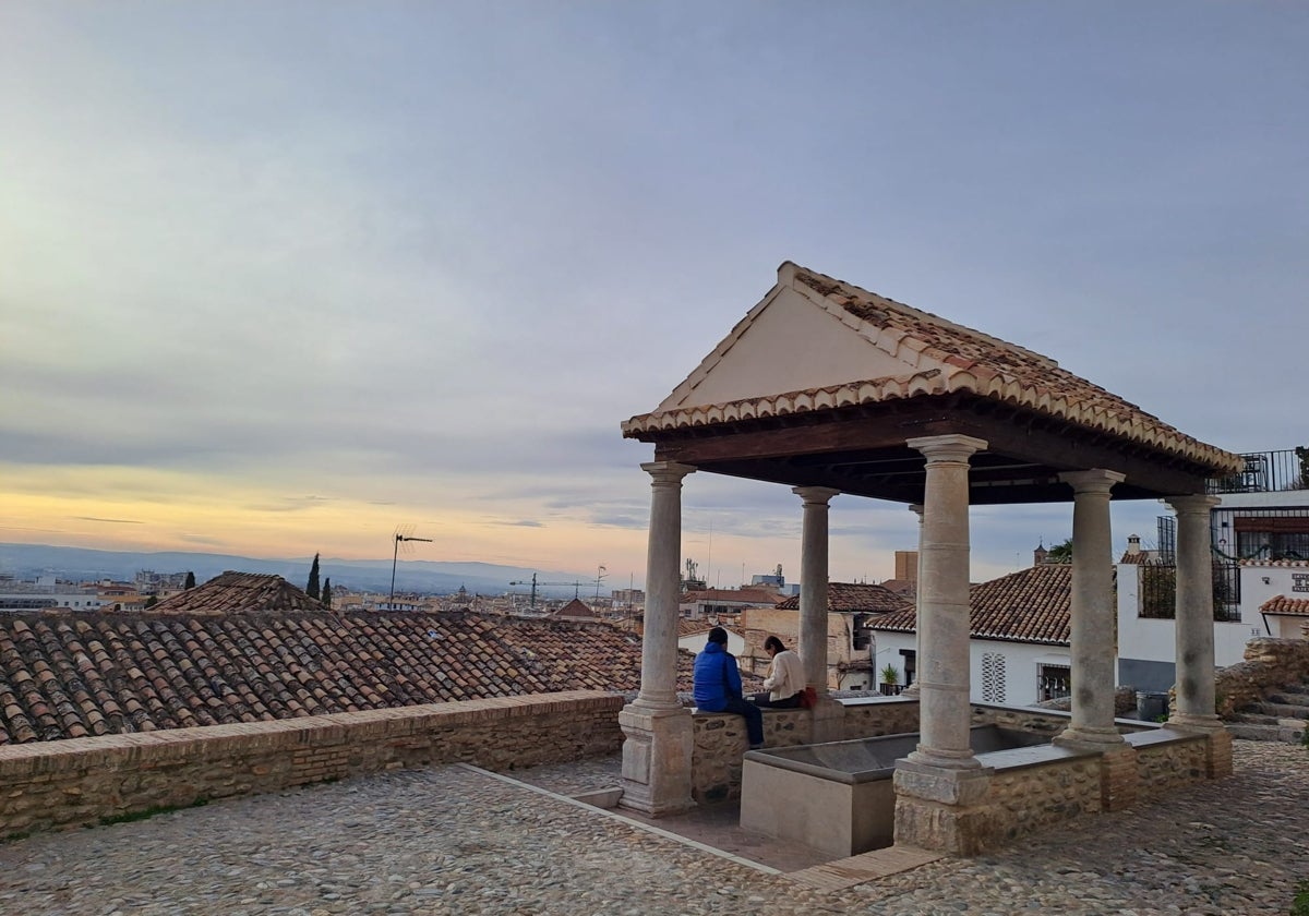 Las últimas luces del día iluminan desde el lavadero los tejados del Realejo con la ciudad al fondo