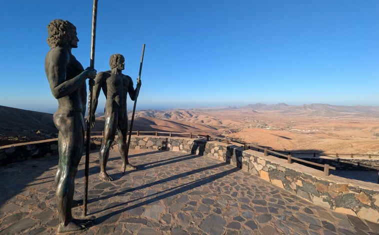 Imagen principal - En la foto superior, el mirador de Guise y Ayose, los dos reyes aborígenes durante la conquista de la isla en el siglo XV, representados en dos esculturas de bronce de cuatro metros de altura. Junto a estas líneas, atardecer en Ajuy y la iglesia de Vega de Río Palmas donde está la talla de la Virgen de la Peña, la patrona de la isla.