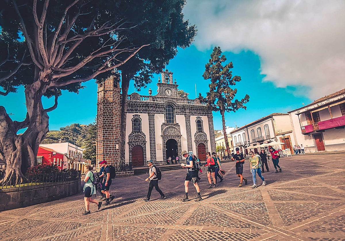 Senderistas atravesando la plaza de Nuestra Señora del Pino de Teror