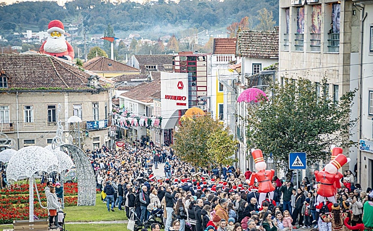 Imagem principal - Moradores celebram o Natal em evento vespertino (acima); o trem histórico da Vogue (canto inferior esquerdo); e uma das ruas do centro da cidade com guarda-chuvas e luzes de Natal (canto inferior direito)